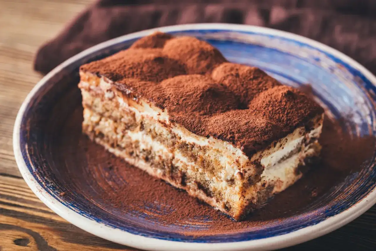 Pyszny deser tiramisu, posypany kakao. Zastanawiasz się, co dać zamiast amaretto? Spróbuj z rumem lub likierem migdałowym.