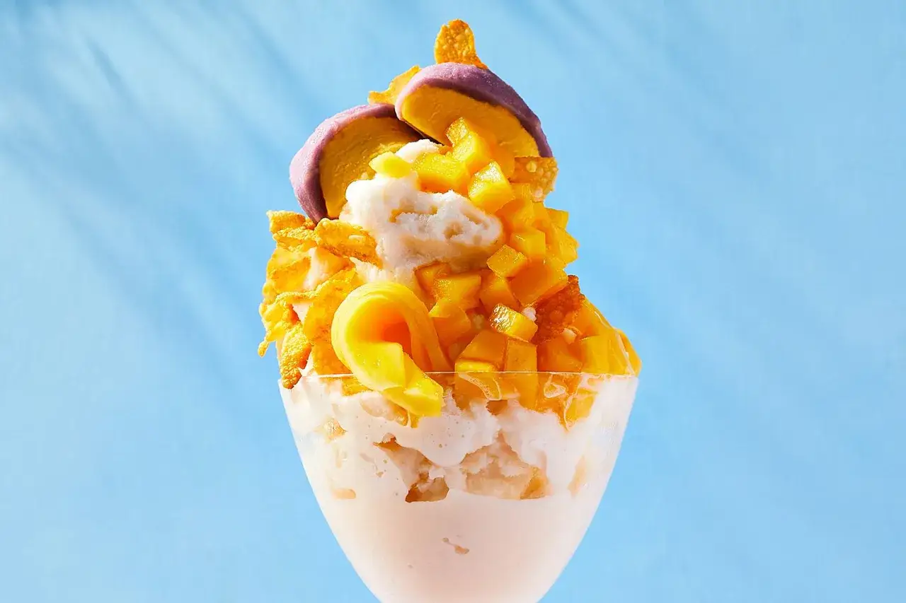 Pyszny deser Bingsu przepis: mrożone mleko, kostki mango, płatki kukurydziane i fioletowe lody.