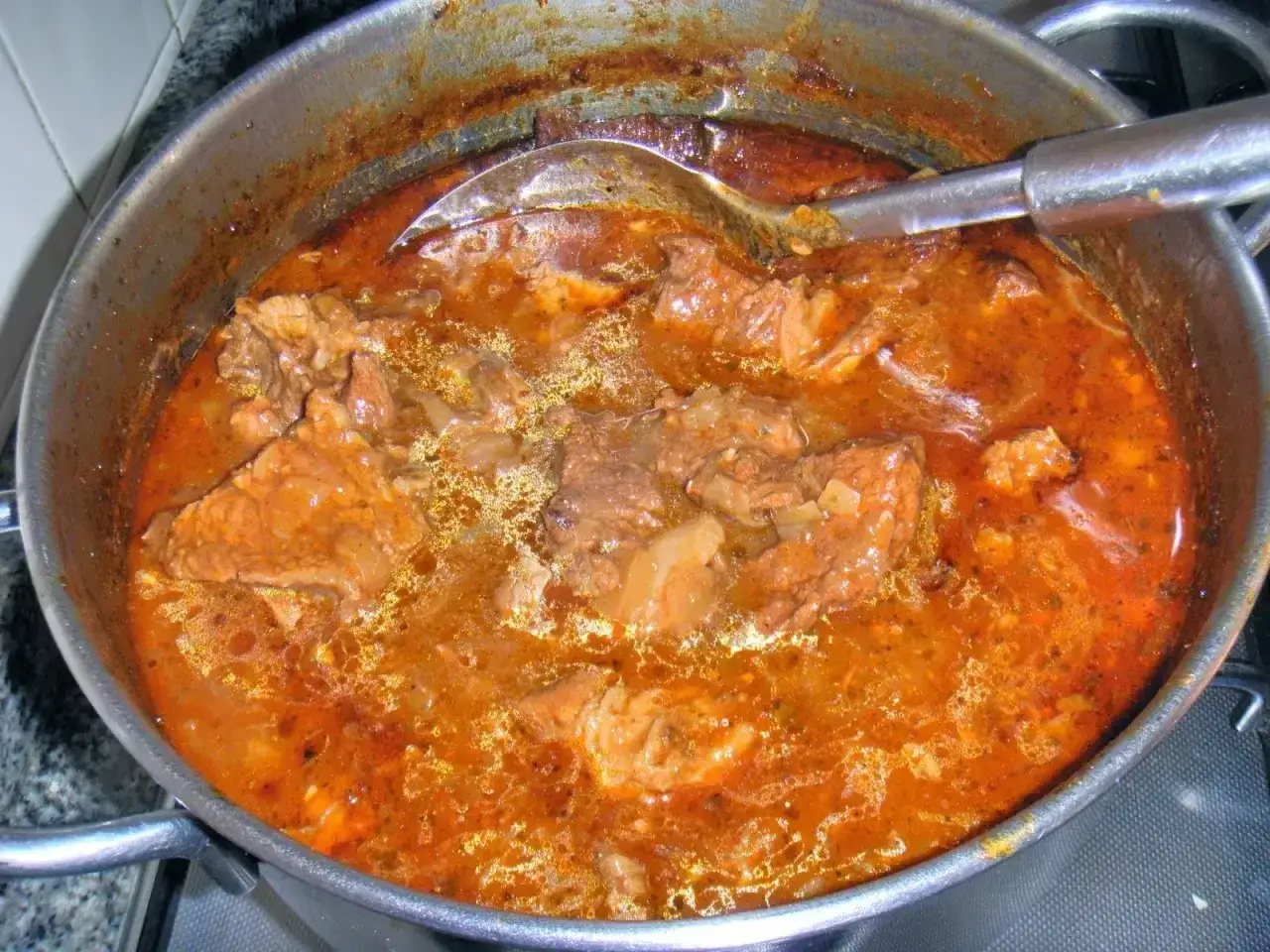Gulasz wołowy i wieprzowy w sosie własnym, gotowany w garnku. Aromatyczny, sycący posiłek.