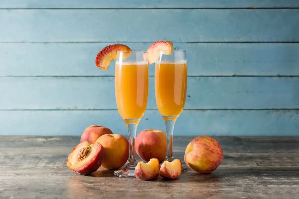 Dwa kieliszki orzeźwiającego drinka Bellini z brzoskwiniami. Idealny przepis na lato.