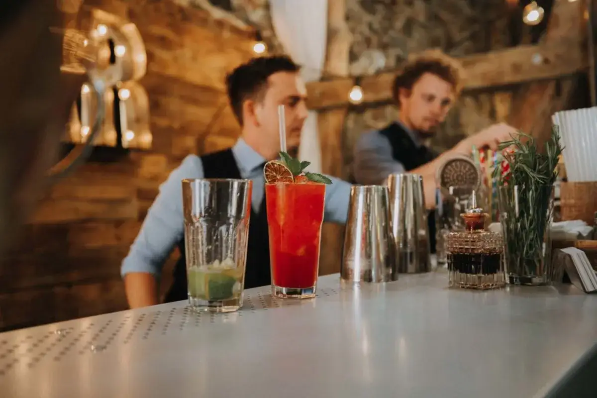 Barmani przygotowują drinki. Zastanawiasz się, ile zarabia barman po kursie?