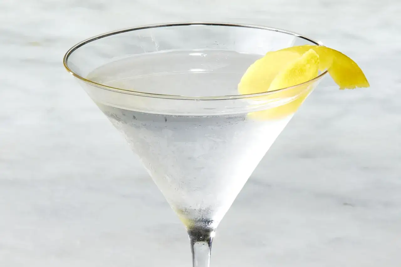 Schłodzone martini w kieliszku, ozdobione skórką cytryny. Idealne na początek przygody z tym, jak zrobić martini.