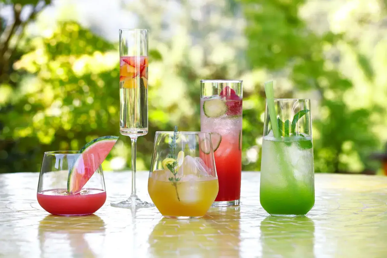 Letnia uczta: Pimm’s No. 1 kontra Aperol Spritz i inne orzeźwiające drinki z owocami i ziołami na stole w ogrodzie.