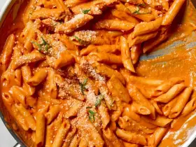 Penne rigate w kremowym sosie pomidorowym, posypane parmezanem i ziołami. Idealne na obiad, czy to penne lisce czy rigate, smakują wybornie.