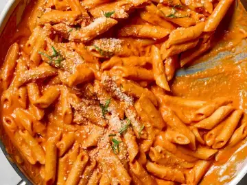 Penne rigate w kremowym sosie pomidorowym, posypane parmezanem i ziołami. Idealne na obiad, czy to penne lisce czy rigate, smakują wybornie.